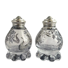 Load image into Gallery viewer, These vintage Imperial Candlewick clear glass salt and pepper shakers are beautifully decorated with silver overlay of orchid flowers. Crafted by Imperial Glass and Silver City, USA, circa 1950s. An lovely addition to your tableware! In excellent condition, free from chips or cracks. The silver overlay is stunning. Measures 1 7/8 x 3 inches
