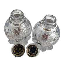 Load image into Gallery viewer, These vintage Imperial Candlewick clear glass salt and pepper shakers are beautifully decorated with silver overlay of orchid flowers. Crafted by Imperial Glass and Silver City, USA, circa 1950s. An lovely addition to your tableware! In excellent condition, free from chips or cracks. The silver overlay is stunning. Measures 1 7/8 x 3 inches
