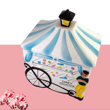 Load image into Gallery viewer, Sweet and rare! Vintage Candy Counter lidded ceramic canister, features a candy vendor alongside his candy cart. The cart has a blue and white striped awning, topped with a lantern and the cart displays a selection of colourful candies. Crafted by Napco Originals, circa 1950s. Marked E-575 Japan on the bottom. A great piece of mid-century kitsch to add to your home or kitchen decor  In excellent condition, free form chips/cracks.  Measure approximately 4 3/4 x 3 1/4 x 6 inches
