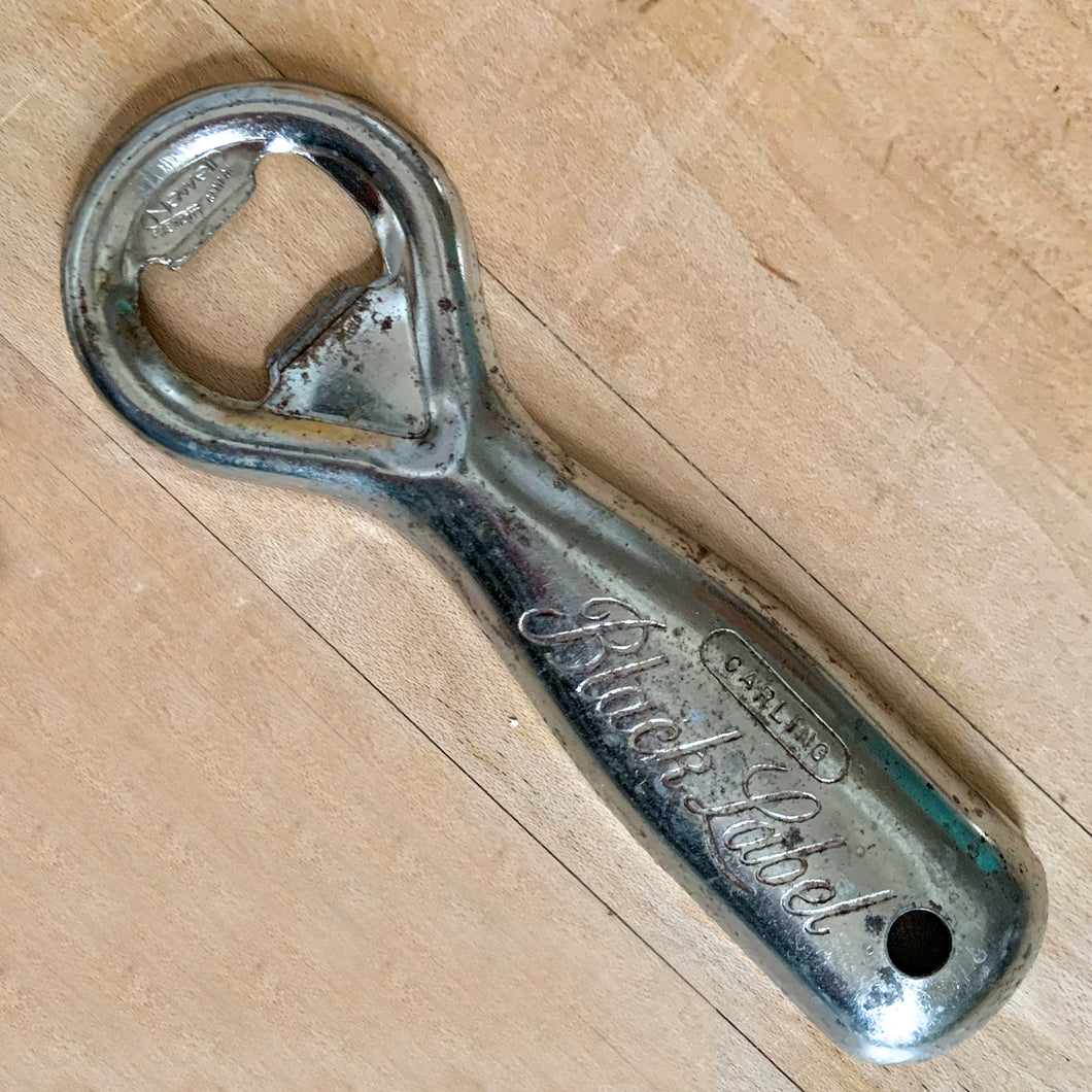 Vintage Carling Black Label classic debossed promotional advertising metal bottle opener with drilled hole for hanging. Crafted by Newell, Canada. A great addition to any beer drinker's barware collection!

In as found vintage condition.

Measures 5 1/4 inches