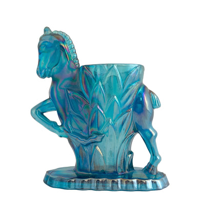 Vintage limited edition Carols Sure Win iridescent Mediterranean Blue Carnival Glass bud vase featuring a horse prancing through vegetation. Made for Cherished Glass Wares by L.E. Smith Glass, USA, 1970s. Production of these vases was limited to approximately 2000 per colour and was produced in Amber, Amberina, Mediterranean Blue and Crystal Lustre.

In excellent condition, no chips. There is a minor rough spot at the seam likely due to mold release.

Measures 4 1/4 x 1 7/8 x 5 1/4 inches