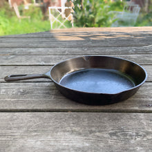 Load image into Gallery viewer, Vintage cast iron 10 1/2 inch frying pan skillet with open handle for easy hanging. Marked Taiwan. We&#39;ve restored this pan and seasoned it with canola oil. Cast iron pans can last a lifetime with proper care and are a great way to add vintage charm to your kitchen decor.

In excellent vintage condition.

Measures 10 7/8 x 15 x 1 3/4 inches (incl. handle)
