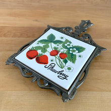Load image into Gallery viewer, Angled view of vintage cast iron trivet with white tile insert featuring strawberries on the vine. Seven Star, Taiwan, 1970s
