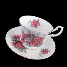 Load image into Gallery viewer, A lovely vintage Centennial Rose Monstrose shaped bone china teacup and saucer. Each piece has a lovely scalloped edge featuring a hand painted rose sprays with gold gilt trim. Crafted by Royal Albert, England, circa 1960s/70s. The perfect vessel for an excellent cuppa tea!

In excellent condition, no chips, cracks or repairs. Maker&#39;s marks on the bottom.

Teacup measures 3 1/2 x 2 3/4 inches | Saucer measures 5 1/2 inches
