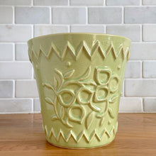 Load image into Gallery viewer, Rare vintage chartreuse green planter pot with embossed flower motif and zig zag borders. Crafted by McCoy Pottery, 1954. This rare planter is must for any McCoy art pottery collector. A wonderful piece to elevate your home and garden decor or to give as a gift!

In as found vintage condition, chip to the rim and crack, no repairs. Normal age-related crazing and manufacturer's glaze pops. Maker's mark on the bottom.

Measures 6 1/2 x 6 1/8 inches
