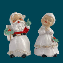 Load image into Gallery viewer, Vintage mid-century beautifully hand painted ceramic Santa and Mrs. Claus salt and pepper shakers. These Christmas themed shakers have the sweetest facial expressions, are nicely painted in red, green and black with gold spaghetti details. Crafted by Lefton, Japan, 1950s. These highly collectible kitschy shakers are the perfect accent for your Christmas holiday decor!
