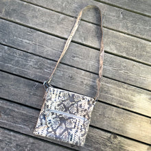 Load image into Gallery viewer, Pre-owned Ciana taupe faux python cross-body bag with adjustable strap is crafted from durable textured cow leather and features polished silver tone hardware. By Danier Leather. The zippered polyester lined interior has three compartments, one zippered pocket and metal keychain holder, one with snap closure, and one with 2-part open pocket. Exterior 2 zippered and snap closure pockets. A stylish, durable and practical accessory.
