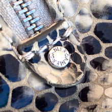 Load image into Gallery viewer, Pre-owned Ciana taupe faux python cross-body bag with adjustable strap is crafted from durable textured cow leather and features polished silver tone hardware. By Danier Leather. The zippered polyester lined interior has three compartments, one zippered pocket and metal keychain holder, one with snap closure, and one with 2-part open pocket. Exterior 2 zippered and snap closure pockets. A stylish, durable and practical accessory.
