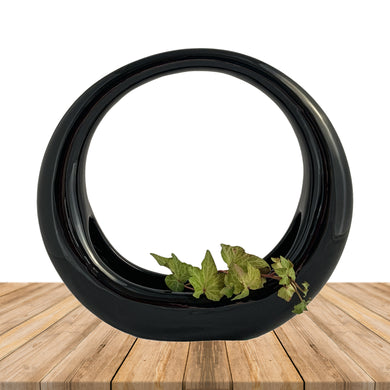 Vintage retro art deco style circular ceramic planter finished in glossy black or white glaze and felted bottom. Crafted by Sedan Manufacturing, Canada, circa 1980s. Nestle in a few of your favourite plants or succulents to create a lovely little container garden or put together a sweet holiday display with bottle brush Christmas trees and ornaments.