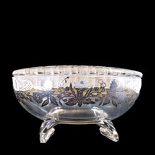 Load image into Gallery viewer, This exquisite vintage flowerlite features a clear oval or oblong shape adorned with a delicate silver overlay of orchid flowers. Crafted by Viking Art Glass in the 1950s, it includes a glass flower frog designed to hold two taper candles and rests on elegant Chinoiserie-style scrolled feet. Ideal for creating sophisticated floral arrangements, this Hollywood Regency piece enhances any space with timeless charm, whether illuminated by candlelight or displayed on its own in both modern and vintage interiors.
