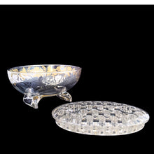 Load image into Gallery viewer, This exquisite vintage flowerlite features a clear oval or oblong shape adorned with a delicate silver overlay of orchid flowers. Crafted by Viking Art Glass in the 1950s, it includes a glass flower frog designed to hold two taper candles and rests on elegant Chinoiserie-style scrolled feet. Ideal for creating sophisticated floral arrangements, this Hollywood Regency piece enhances any space with timeless charm, whether illuminated by candlelight or displayed on its own in both modern and vintage interiors.
