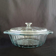 Load image into Gallery viewer, This large vintage clear glass lidded casserole dish has a distinctive scalloped design that makes cooking and serving effortless. It is oven, microwave, and dishwasher safe, making it easy to transport and reheat your favorite dishes with minimal mess. Crafted by Anchor Hocking, USA, circa 1950s, this dish is sure to bring style and convenience to your kitchen.  In excellent condition, free from chips.  Measures 9 inches / 23 cm  Capacity 2 quarts/litres
