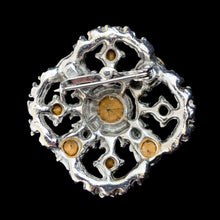 Load image into Gallery viewer, Reverse of vintage rhinestone brooch showing silver-tone openwork back, pin clasp, and foil-backed stone settings

