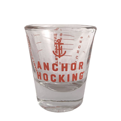 Clear shot glass displaying the Anchor Hocking logo and measures red. Crafted by Anchor Hocking, USA.  In excellent condition, no chips.  Measures 2 x 2 1/4 inches  Capacity 1 ounce