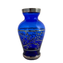 Load image into Gallery viewer, Vintage cobalt blue hand blown Murano art glass bud vase decorated with a Venetian scene and florals in silver overlay. Crafted in Italy, 1950s. A lovely piece of art glass from the mid-century, perfect for display and even sweeter with a bouquet of flowers.

In excellent condition, no chips.

Measures 2 1/2 x 2 1/2 x 4 3/4 inches
