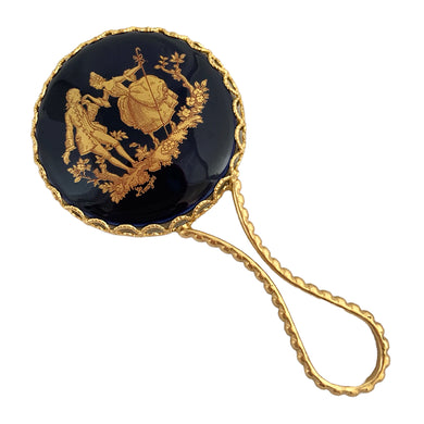 Vintage cobalt blue porcelain hand mirror featuring hand painted gold gilt courting couple and filigree. Signed Limoges. Made in France. Add elegance to your vanity with this lovely piece. In excellent condition, free from chips/wear. Measures 2 1/4 x 4 3/4 inches