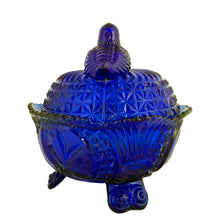 Load image into Gallery viewer, Large vintage cobalt blue love birds 3-footed, lidded candy dish, Byrdes reproduction. A licensed reproduction of the Hofbauer Byrdes model, 1990s. A gorgeous vessel to stash candy, keys, cotton balls and more!!!

In vintage condition with minor smooth chip to the outer rim and minor flea bites to both pieces which do not detract from the beauty of this piece thanks to the deep colour of the glass which tends to hide small issues.

Measures 7 1/2 x 7 1/2 inches
