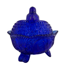 Load image into Gallery viewer, Large vintage cobalt blue love birds 3-footed, lidded candy dish, Byrdes reproduction. A licensed reproduction of the Hofbauer Byrdes model, 1990s. A gorgeous vessel to stash candy, keys, cotton balls and more!!!

In vintage condition with minor smooth chip to the outer rim and minor flea bites to both pieces which do not detract from the beauty of this piece thanks to the deep colour of the glass which tends to hide small issues.

Measures 7 1/2 x 7 1/2 inches
