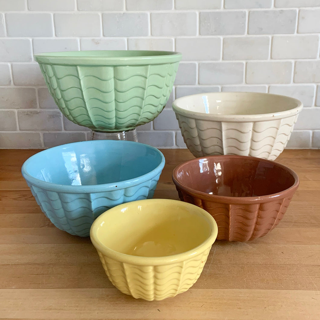 Vintage set of five ceramic nested mixing bowls with an exterior pattern of horizontal waves. Crafted by Robinson Ransbottom Pottery Co., USA, 1960s. A beautiful set to add to your kitchen's art pottery collection!

Measurements and Condition

No chips/cracks/repairs, wear commensurate with age, manufacturer's glaze pops and maker's marks.

Mint Green, 9 1/4 x 4 3/4 inches.

White, 8 1/4 x 4 1/2 inches.

Blue, 7 1/4 x 3 3/4 inches.

Cinnamon, 6 1/4 x 3 inches

Yellow, 5 1/8 x 2 5/8 inches
