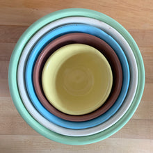 Load image into Gallery viewer, Vintage set of five ceramic nested mixing bowls with an exterior pattern of horizontal waves. Crafted by Robinson Ransbottom Pottery Co., USA, 1960s. A beautiful set to add to your kitchen&#39;s art pottery collection!

Measurements and Condition

No chips/cracks/repairs, wear commensurate with age, manufacturer&#39;s glaze pops and maker&#39;s marks.

Mint Green, 9 1/4 x 4 3/4 inches.

White, 8 1/4 x 4 1/2 inches.

Blue, 7 1/4 x 3 3/4 inches.

Cinnamon, 6 1/4 x 3 inches

Yellow, 5 1/8 x 2 5/8 inches
