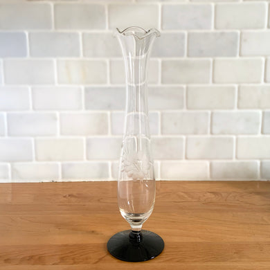 Vintage WJ Hughes cut Corn Flower clear glass amethyst footed bud vase with crimped rim. The vase is cut with one 12-petalled corn flower and leaf spray. Unknown blank. 1970s. Create a sweet floral arrangement with this lovely vessel!

In excellent condition, free from chips or cracks.

Measures 2 3/4 (at foot), 2 (at rim) x 9 3/4 inches tall