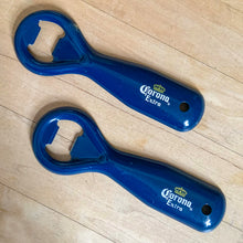 Load image into Gallery viewer, Vintage Corona Extra classic promotional advertising blue enamel coated metal bottle opener with drilled hole for hanging. Crafted by Ledco, Canada. A great addition to any beer drinker&#39;s barware collection!

In as found vintage condition.

Measures 5 1/4 inches
