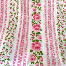 Load image into Gallery viewer, Lovely vintage white flat bed sheet printed with a pattern flowers and stripes in shades of pink with green leaves. This 50% polyester / 50% cotton sheet fits a double/full sized bed. Crafted by Wabasso, Canada, circa 1970s. A beautiful addition to your bedding collection, or repurpose for crafts, quilting or garment making.
