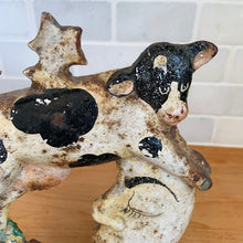 Load image into Gallery viewer, Rare early 20th century vintage The Cow Jumped Over the Moon nursery rhyme hand painted cast iron doorstop. Signed by the artist Arni on the base. This solid, one-piece diecast cut doorstop is an original free of mold seams, screws or grind marks and weighs 4 1/4 pounds. A wonderful piece of folk art to add charm to your home&#39;s decor.

In as found vintage condition with wear to the paint and rusty patina.

Measures 7 x 8 1/2 inches
