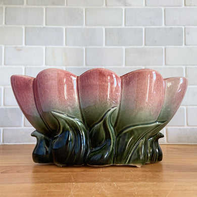 Gorgeous ceramic planter 118 featuring leaves at the base that lead to a lotus shaped oblong bowl, glazed in a gorgeous deep green that transitions to cranberry pink at the top. Crafted by Hull Pottery in the USA, circa 1950s. The subtle ombre glaze and the striking design gives this planter great dimension. Any plant would be happy to call it home! In excellent condition, free from chips/cracks/repairs. Measures 10 3/8 x 4 ½ x 5 inches
