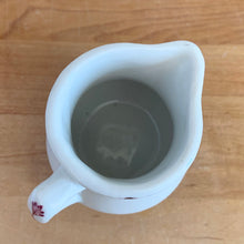 Load image into Gallery viewer, Vintage cranberry red floral transferware white ceramic handled creamer. Crafted by McNicol China, USA. The charming sidekick to your morning coffee or tea!

In excellent condition, no chips/cracks.

Measures 2 3/4 x 2 3/4 inches
