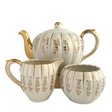 Load image into Gallery viewer, Vintage &quot;W777&quot; ceramic teapot, creamer and sugar set featuring gold flowers and trim on a ribbed shape. Crafted by Gibsons, England, circa 1950s. A must-have for any tea enthusiast! In excellent condition, free from chips/cracks/repairs.
