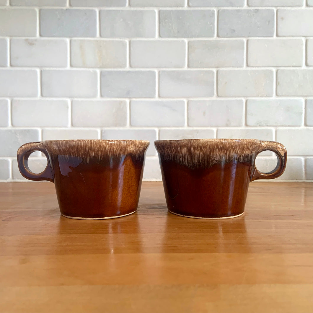 Pair of vintage Crestone glossy brown drip glaze mugs with flare rim. Crafted by Hull Pottery, USA, 1960s. Enjoy any hot beverage in this fabulous retro oven-proof tableware!

In excellent condition, no chips/cracks/repairs. Maker's marks.

Measures 4 x 2 3/4 inches

Capacity 8 ounces