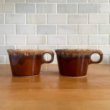 Load image into Gallery viewer, Pair of vintage Crestone glossy brown drip glaze mugs with flare rim. Crafted by Hull Pottery, USA, 1960s. Enjoy any hot beverage in this fabulous retro oven-proof tableware!

In excellent condition, no chips/cracks/repairs. Maker&#39;s marks.

Measures 4 x 2 3/4 inches

Capacity 8 ounces
