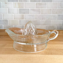 Load image into Gallery viewer, We are loving this vintage clear depression glass &quot;Criss Cross&quot; citrus juice reamer. Every home should have one of these practical kitchen helpers that makes squeezing oranges, lemons and limes a breeze! This one has a convenient spout and smooth finger handle design. Produced by Hazel-Atlas Glass, USA, circa 1930s. Perfect for the fresh squeezed juice enthusiast...no sugar added! In excellent condition, free from chips/wear. Measures 5 3/4 x 3 1/2 inches
