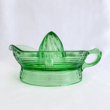 Load image into Gallery viewer, We are loving this vintage green uranium depression glass &quot;Criss Cross&quot; citrus juice reamer. This piece is extra special because it glows brilliantly under black light! Every home should have one of these practical kitchen helpers that makes squeezing every juicy ounce from your oranges, lemons and limes super easy! This one has a convenient spout and smooth finger handle design. Produced by Hazel-Atlas Glass, USA, circa 1930s. Perfect for the fresh squeezed juice enthusiast...no sugar added! 
