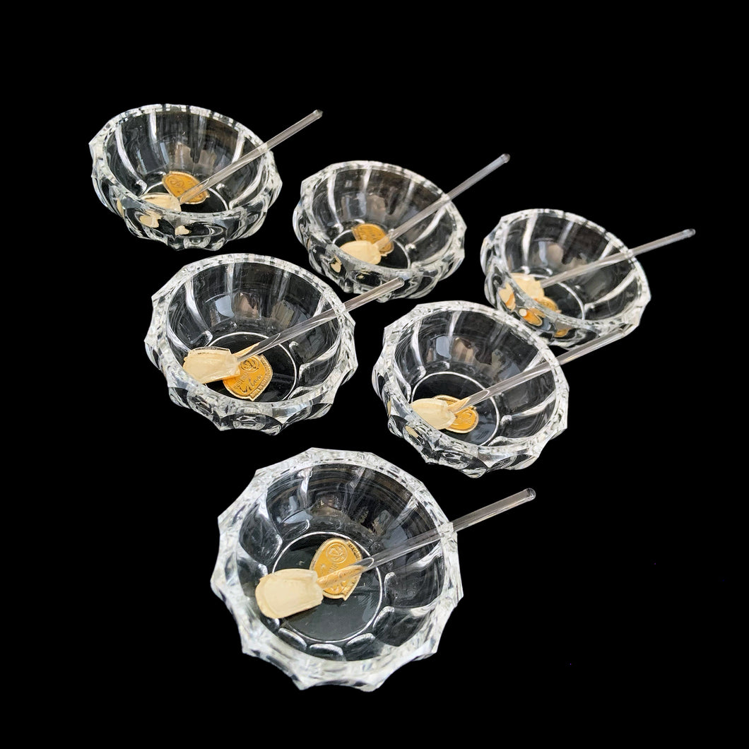 Vintage set of six crystal salt cellars and spoons. Crafted by Bohemia Crystal, circa 1950s. A lovely addition to your tablescape. While the cellars and spoons are new in box, some have rough edges from mold release. Each piece has the original yellow sticker which read Bohemia Crystal, Made in Czechoslovakia. Salt cellars measure 2 3/8 x 7/8 inches. Spoons measure 2 3/4 inches