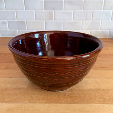 Vintage Daisy and Dots old fashioned stoneware bowl featuring a deep brown glaze decorated with a Pennsylvania Dutch pattern of daisy, dots, on bands with scalloped design and smooth rim. A lovely early American farmhouse themed bowl, perfect for mixing, displaying fruit. Also a nice piece to fill with pinecones or carpet balls to use as decor.

In excellent condition, no chips/cracks/repairs.

Measures 7 3/4 x 4 1/2 inches

Capacity 1 3/4 quarts