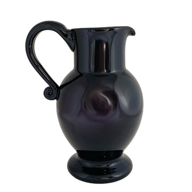 Vintage deep purple hand blown glass pitcher with applied curled handle and smooth pontil. Maker unknown. A stunning and versatile pitcher that may be used to serve your favourite beverage, serve as a flower vase or artisanal glass decor.

In excellent used condition, no chips, minor wear.

Measures 7 x 5 x 10 (incl handle/spout)