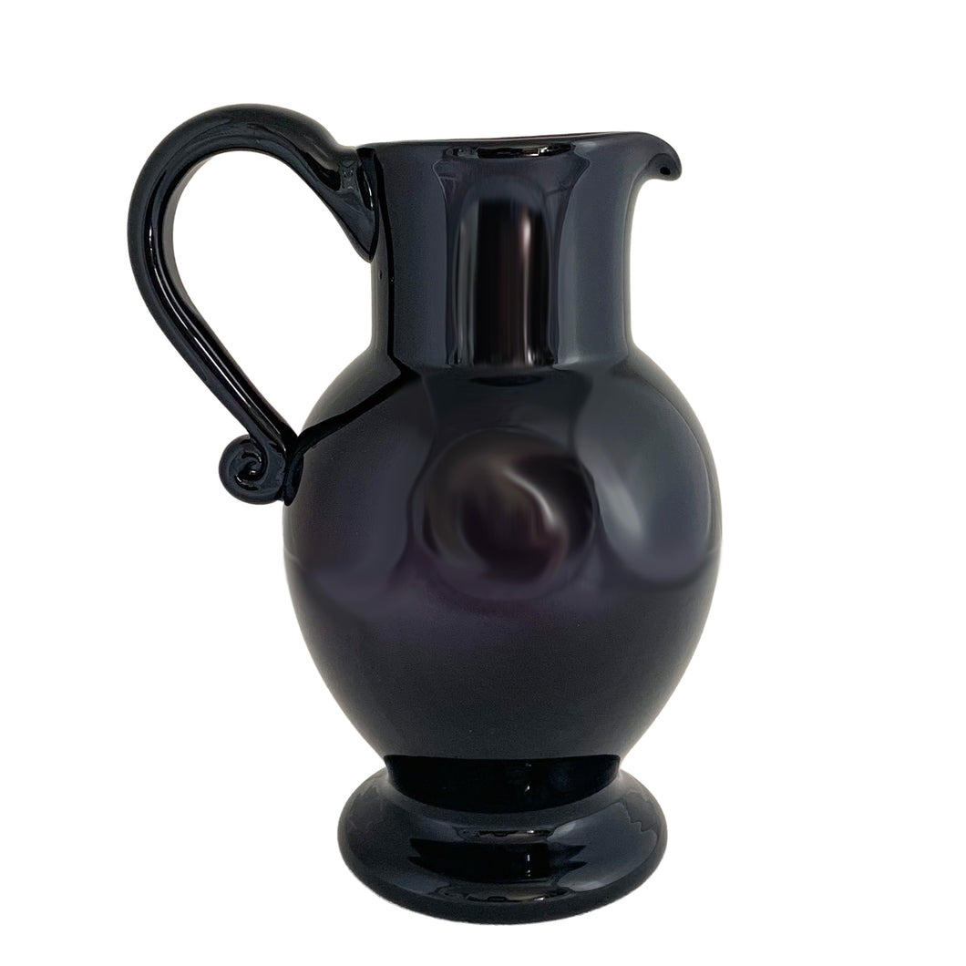 Vintage deep purple hand blown glass pitcher with applied curled handle and smooth pontil. Maker unknown. A stunning and versatile pitcher that may be used to serve your favourite beverage, serve as a flower vase or artisanal glass decor.

In excellent used condition, no chips, minor wear.

Measures 7 x 5 x 10 (incl handle/spout)