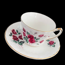 Load image into Gallery viewer, Vintage fine bone china teacup and saucer featuring dark pink roses, pale blue baby&#39;s breath and gold gilt trim on a swirl shape. Crafted by Delphine, England, 1930 - 1941. A lovely way to enjoy a cuppa tea!

In excellent condition, no chips, cracks or repairs. Maker&#39;s mark on the bottom.

Measures 3 3/8 x 2 1/2 inches | Saucer measures 5 3/4 inches
