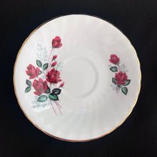 Load image into Gallery viewer, Vintage fine bone china teacup and saucer featuring dark pink roses, pale blue baby&#39;s breath and gold gilt trim on a swirl shape. Crafted by Delphine, England, 1930 - 1941. A lovely way to enjoy a cuppa tea!

In excellent condition, no chips, cracks or repairs. Maker&#39;s mark on the bottom.

Measures 3 3/8 x 2 1/2 inches | Saucer measures 5 3/4 inches
