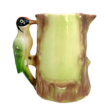 Load image into Gallery viewer, Side profile of vintage Ditmar-Urbach Majolica woodpecker pitcher — green and brown tree-form body with sculpted bird handle, spout visible at right
