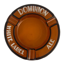 Load image into Gallery viewer, Vintage promotional advertising Dominion White Label Ale amber round glass ashtray. A great piece for the tobacciana and barware collector.  In vintage condition, minor flea bites to the interior rim and wear to the printing.  Measures 6 1/4 x 7/8 inches
