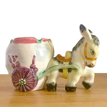 Load image into Gallery viewer, Adorable vintage figural colourful ceramic planter featuring a donkey pulling a cart finished, featuring flower-shaped wheels. Crafted in Japan and marked S3364. Perfect for your favourite houseplant, succulent or repurpose as a pen/pencil or make-up brush holder.   In excellent condition, free from chips/cracks/repairs.  Measures 7 x 4 x 5 inches
