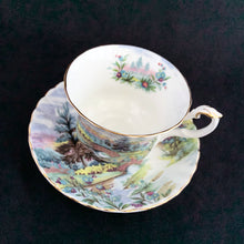 Load image into Gallery viewer, This vintage bone china footed teacup and saucer is so sweet! Both the cup and saucer are decorate with the &quot;Dovedale&quot; pattern from the Country Scenes series. Each piece has a lovely scalloped edge with hand painted whimsical country scene, trimmed with gold gilt. Produced by Royal Albert, England, circa 1917 - 1927.  In excellent condition, free from chips, cracks and repairs. Maker&#39;s marks are on the bottom.   Teacup measures 3 3/8 x 2 3/4 inches  | Saucer measures 5 1/2 inches

