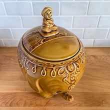 Load image into Gallery viewer, vintage cookie jar of figural elephant features a turbin wearing gentleman sitting on a pillow riding on top which forms the lid&#39;s finial. adorable and the expression on the rider&#39;s face is sassy! The elephant is beautifully decorated in an East Indian motif. Crafted by Noritake, Japan for Giftcraft export. In outstanding condition, free from chips/cracks/wear. We believe this is new old stock. Original sticker present and the bottom has the stamped maker&#39;s mark. Measures 7 1/2 x 5 1/2 x 9 3/4 inches
