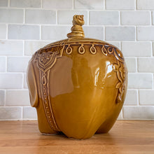 Load image into Gallery viewer, vintage cookie jar of figural elephant features a turbin wearing gentleman sitting on a pillow riding on top which forms the lid&#39;s finial. adorable and the expression on the rider&#39;s face is sassy! The elephant is beautifully decorated in an East Indian motif. Crafted by Noritake, Japan for Giftcraft export. In outstanding condition, free from chips/cracks/wear. We believe this is new old stock. Original sticker present and the bottom has the stamped maker&#39;s mark. Measures 7 1/2 x 5 1/2 x 9 3/4 inches
