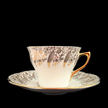 Load image into Gallery viewer, Vintage Elizabethan fine bone china Clare teacup and saucer with colourful roses and gold gilt filigree and trim. Crafted by Taylor &amp; Kent, England, 1980s. A lovely way to enjoy a cuppa tea!

In excellent condition, no chips, cracks or repairs. Maker's mark on the bottom.

Measures 3 3/8 x 2 1/2 inches | Saucer measures 5 5/8 inches
