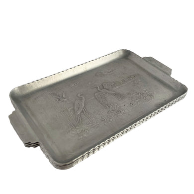 Set of four vintage mid-century era hammered aluminum handled trays featuring embossed herons on water with sawtooth edge detail. Made in the USA, circa 1950s. These trays are perfect for serving candies, or use them to complement your barware.

In excellent vintage condition.

Measures 7 x 4 x 3/8 inches