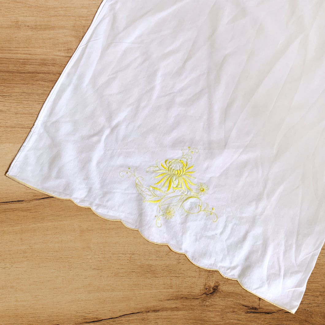 A lovely pair of vintage white cotton pillowcases, featuring elegantly design of hand embroidered flowers and scalloped edge in sunny yellow. A gorgeous addition to your bed linens! In excellent condition, free from tears or stains. Measures 30 1/2 x 19 1/2 inches